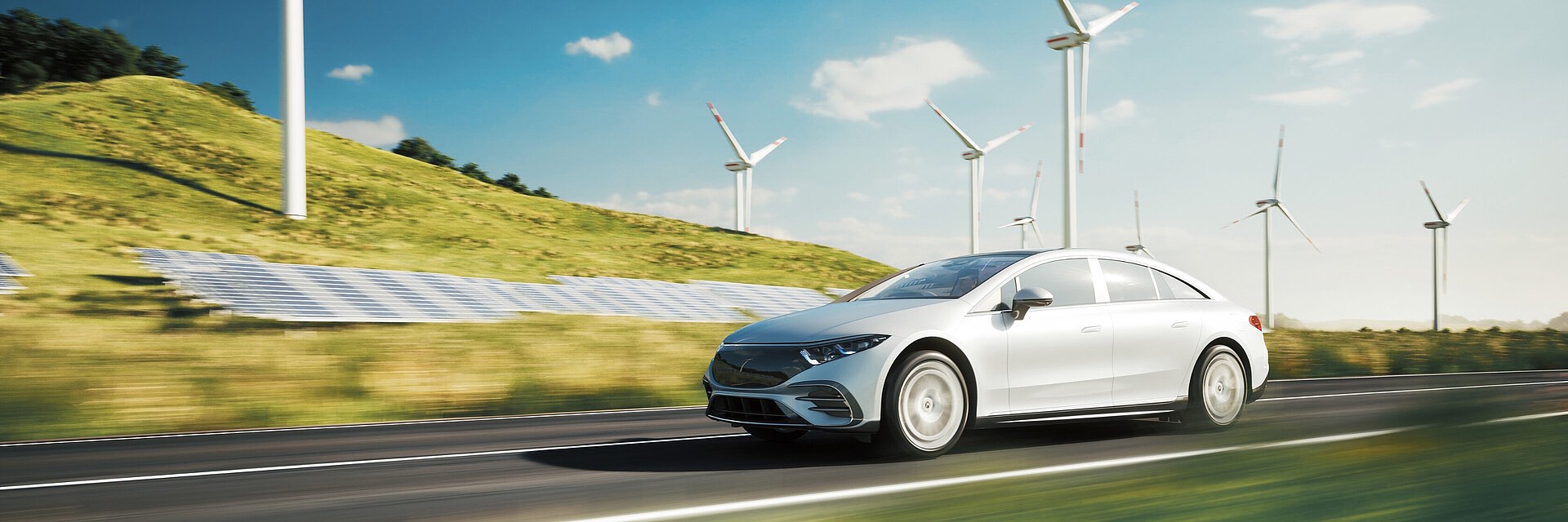 Elektrischer Sportwagen fährt an Solaranlagen und Windrädern vorbei