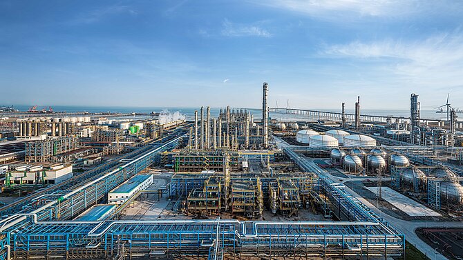 Aerial panoramic view of a massive coastal oil refinery and petrochemical industrial complex.