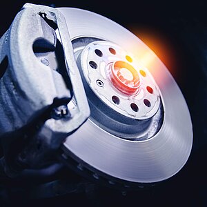Closeup steel brake disk and detail of wheel hub with sunlight
